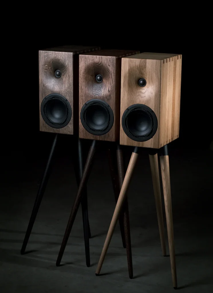 The different finishes of the Buchardt E50 speakers with oak wood cabinet and rounded edges on stands